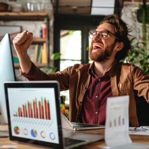 A business owner visibly happy with the success of his Google ads campaign while looking at charts going up.